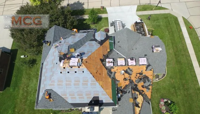 A group of people working on the roof of a house.